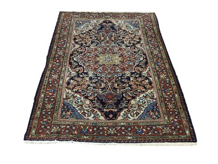 Tappeto persiano fondo blu notte, campo con motivi floreali, volute e girali...