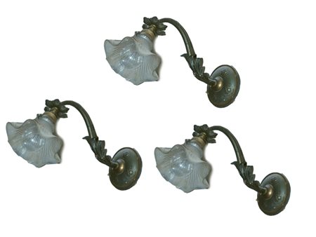 Serie di tre appliques in metallo un braccio portacandela, due con bobeches a...