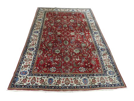 Tappeto persiano fondo rosso, campo con motivi floreali e vegetali nei toni...