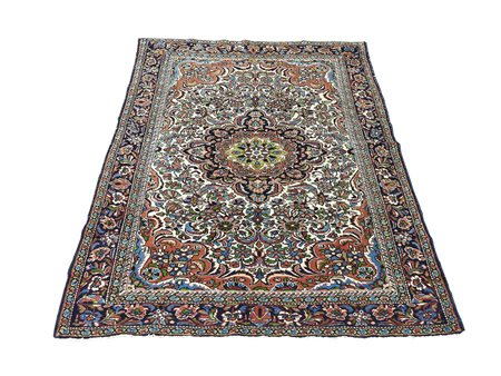 Tappeto persiano fondo beige, campo con medaglione centrale e motivi floreali...