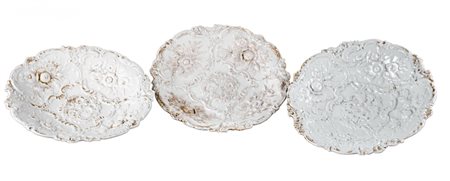 TRE PIATTI in ceramica Meissen smaltata nei toni del bianco e lumeggiata in...