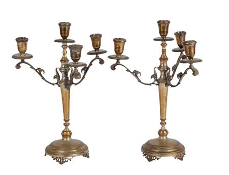 COPPIA CANDELIERI a quattro fiamme in metallo argentato. XX secolo Misure: h...