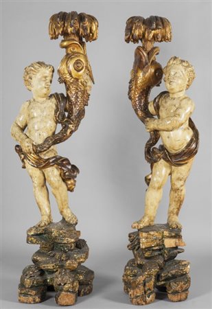 Coppia di putti portatorciera a forma di delfino in legno intagliato, laccato...