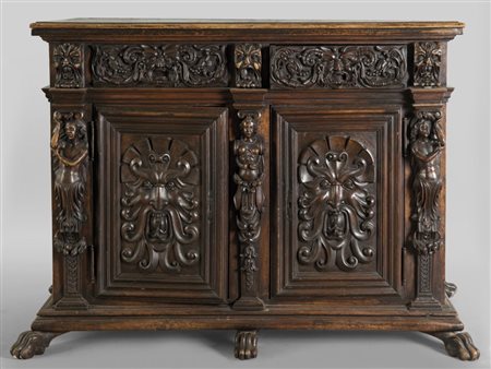 Credenza a due sportelli e due cassetti riccamente intagliata con mascheroni...