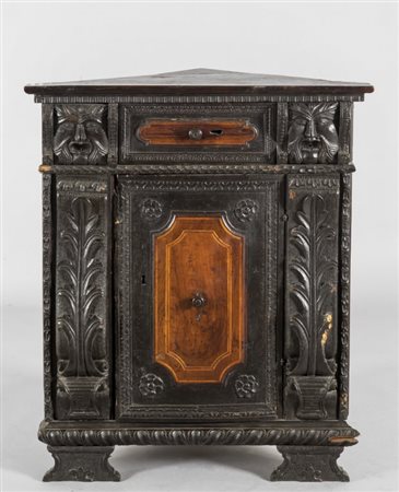 Cantonale con cassetto e sportello intarsiati, ai lati mascheroni intagliati,...