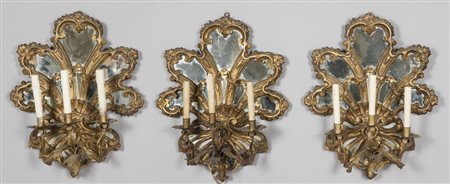 Cinque apliques a tre luci a ventaglio in legno intagliato e dorato con...