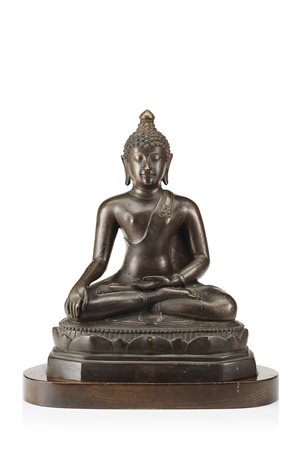 Buddha in bronzo, rappresentato seduto a gambe incrociate, indossa semplici...