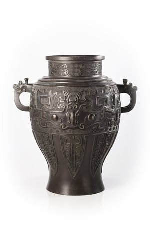 Vaso biansato in bronzo, con decorazione aracaica a rilievo di maschere...