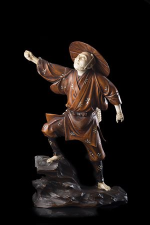 Scultura in avorio e legno raffigurante pescatore con cappello su roccia...