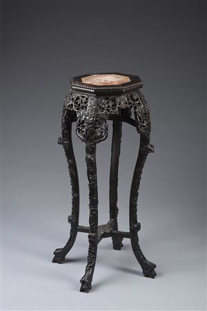 Colonna portavaso in legno ebanizzato intagliato a motivi vegetali con piano...