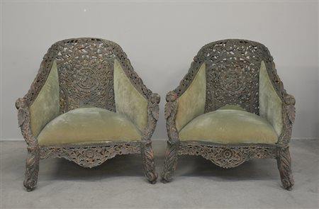 Due poltrone anglo-indiane in legno scuro intagliate e lavorate riccamente...