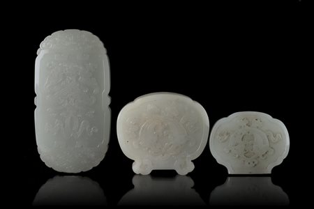 Tre placche in giada bianca e color celadon chiaro, la più grande incisa con...