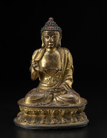 Buddha in bronzo dorato raffigurato seduto in dhysanasana su un piedistallo a...