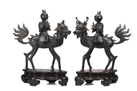 Coppia di bronzo raffiguranti fanciulli a dorso di qilin, indossano lunghe...