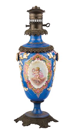 Coppia di lumi a petrolio in porcellana celeste decorati con scene di putti....