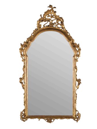 Antica specchiera veneta in legno intagliato e dorato. Decori a volute,...