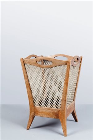 UN CESTINO GETTACARTE, anni '40. Legno di noce, lamierino di ferro traforato....