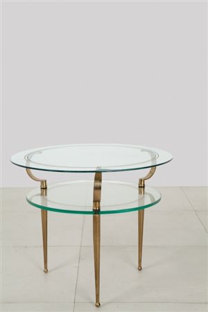 UN TAVOLINO, anni '50. Ottone, cristallo con incisioni circolari dorate....