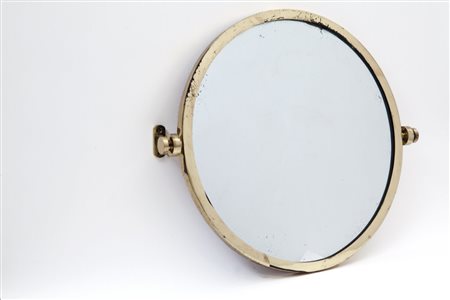 UNO SPECCHIO DA PARETE OSCILLANTE, anni '60. Ottone, cristallo argentato....