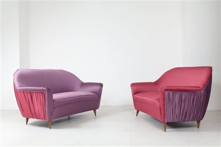 UNA COPPIA DI DIVANI, anni '60. Strutture e gambe di legno, imbottiture...