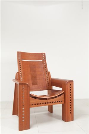 UNA POLTRONA, anni '80. Legno intagliato. Marcata "Cooperativa Llamellin...