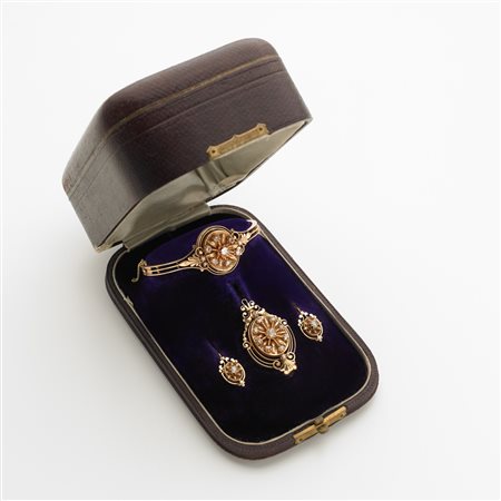 Demi-parure in oro giallo rossastro con bracciale rigido, spilla ed orecchini...