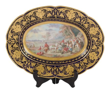 PIATTO ovale in porcellana di Sevres lumeggiata in oro con fondo dipinto...