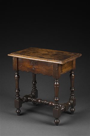 Antico tavolino in noce a quattro gambe e traverse tornite. Fasce sagomate...