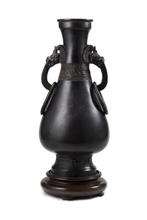 Vaso in bronzo dalla forma arcaica, con doppie anse e anelli in sospensione,...