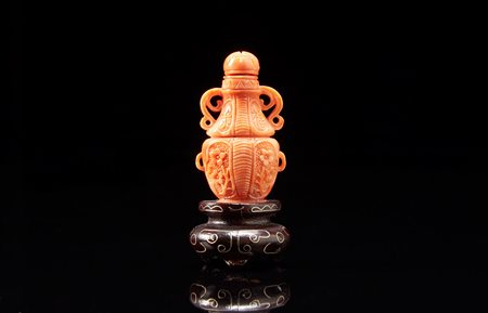 Snuff bottle in corallo, con base in legno Cina, sec. XX A coral snuff bottle...