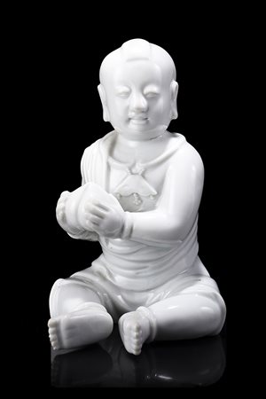 Fanciullo in Blanc-de-Chine raffigurato seduto con una pesca in mano; con...