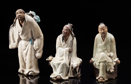 Tre figure in grès porcellanato raffigurate con lunghe tuniche dal color...