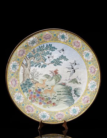 Grande piatto decorato a smalti nel cavetto con cervi e aironi in un...