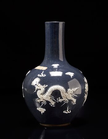 Vaso in porcellana decorato con draghi bianchi in rilievo su fondo blu con...