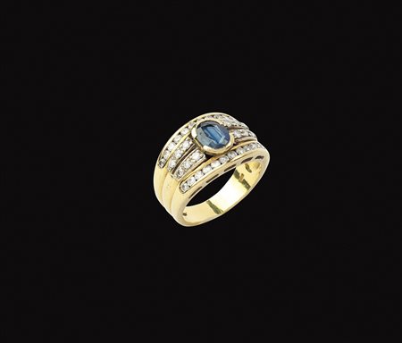 Anello a fascia in oro giallo 18kt peso 8,8 gr. con al centro zaffiro taglio...