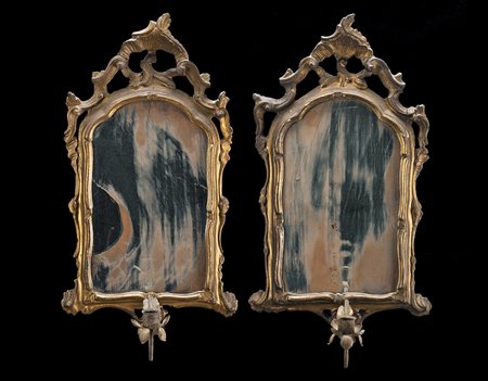 Due specchierine in legno intagliato e dorato con cimasa traforata....