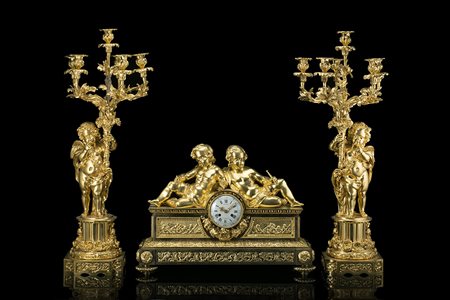 Trittico da camino in bronzo dorato composto da coppia di candelieri a sei...