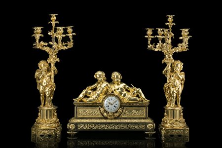 Trittico da camino in bronzo dorato composto da coppia di candelieri a sei...