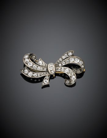 Spilla in oro giallo e argento a guisa di fiocco con diamanti g. 8, largh. cm...