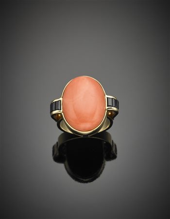 Anello in oro giallo con zaffiri a baguette sul gambo e al centro un corallo...