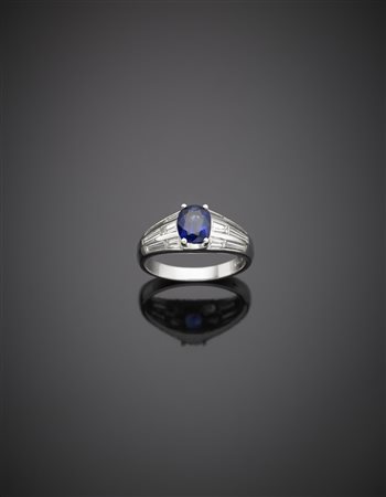Anello in oro bianco con diamanti tapered a contornare uno zaffiro ovale...