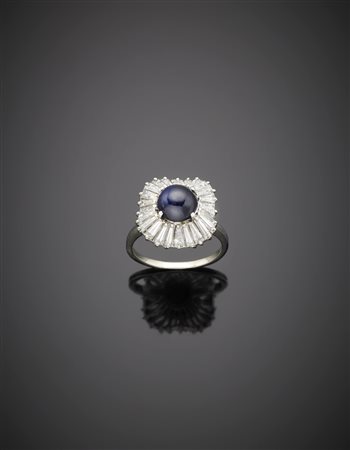 Anello in oro bianco con zaffiro rotondo cabochon contornato da diamanti...