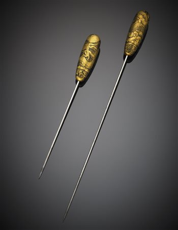 Due spilloni in metallo con cappuccio orientale in oro giallo inciso con...