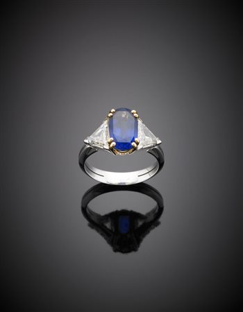 Anello in oro bianco e giallo con uno zaffiro ovale di ct. 3,80, e due...