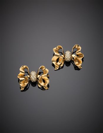 Due spille a guisa di fiocco in oro giallo e bianco g. 11,20 Two bi-cooured...