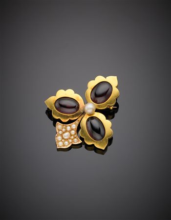 Spilla in oro giallo con tre granati ovali cabochon, mezze perle ed al centro...