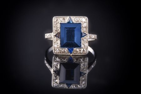 Anello decorato in platino con zaffiro centrale naturale e triangoli laterali...