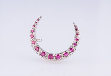 Spilla a mezzaluna in oro bianco gr 6 e rubini per cts. 0,45 circa, diamanti...